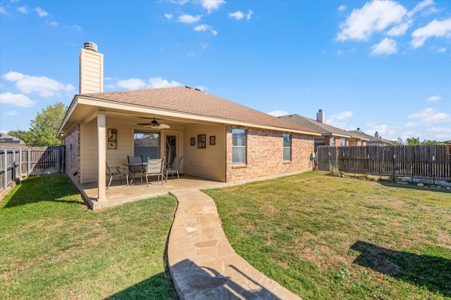 rear view of property with a patio, ceiling fan, and a lawn