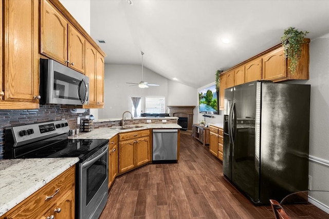 kitchen featuring lofted ceiling, ceiling fan, appliances with stainless steel finishes, dark wood-type flooring, and sink