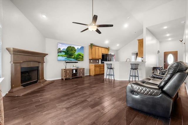 living room with ceiling fan, high vaulted ceiling, and dark hardwood / wood-style flooring