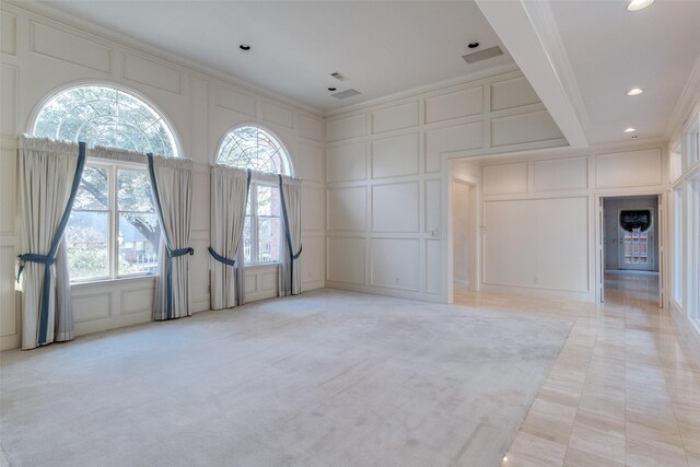 unfurnished living room with crown molding and light colored carpet