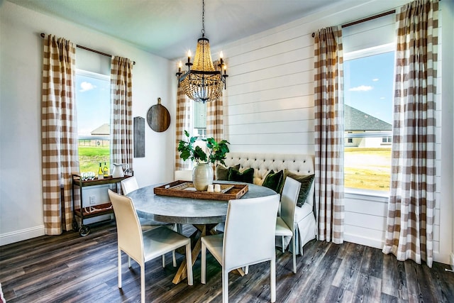 dining space featuring baseboards, dark wood-type flooring, and an inviting chandelier