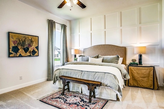 bedroom with light carpet, ceiling fan, a decorative wall, and baseboards