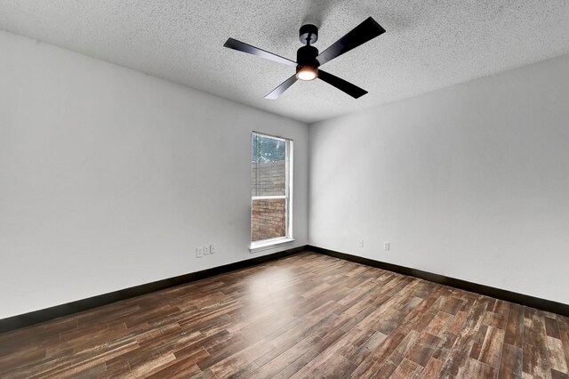 spare room with dark wood-type flooring, a textured ceiling, and ceiling fan