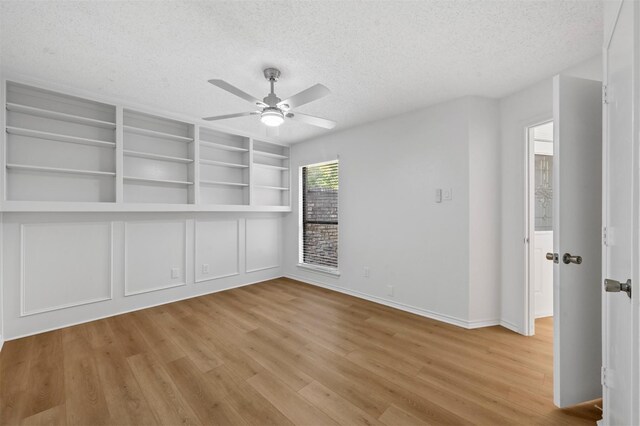 empty room with light hardwood / wood-style flooring, a textured ceiling, and ceiling fan