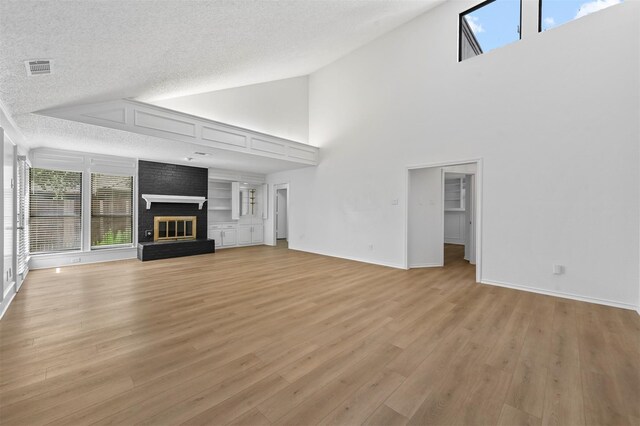 unfurnished living room with a textured ceiling, high vaulted ceiling, and a wealth of natural light