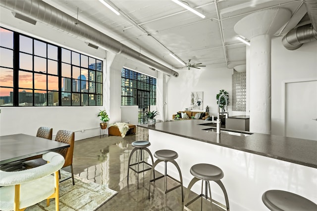 kitchen featuring ceiling fan, sink, and concrete floors