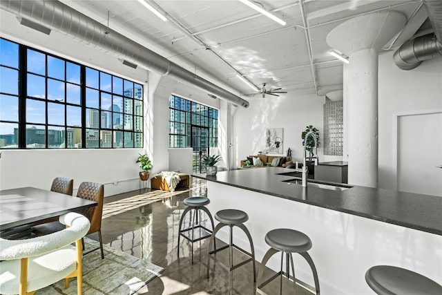 kitchen with ceiling fan, sink, and concrete floors