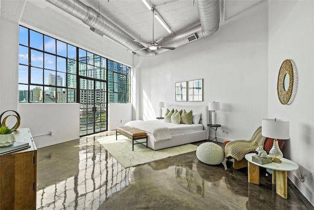 bedroom featuring ceiling fan, a towering ceiling, and concrete floors