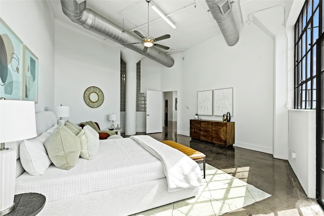 bedroom featuring ceiling fan and a towering ceiling