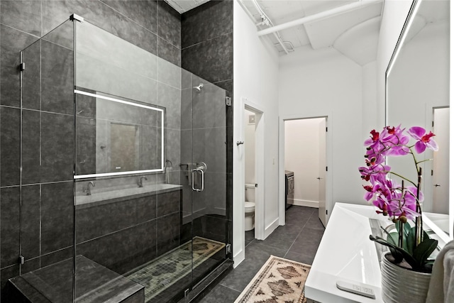 bathroom featuring an enclosed shower, vanity, tile patterned floors, and toilet