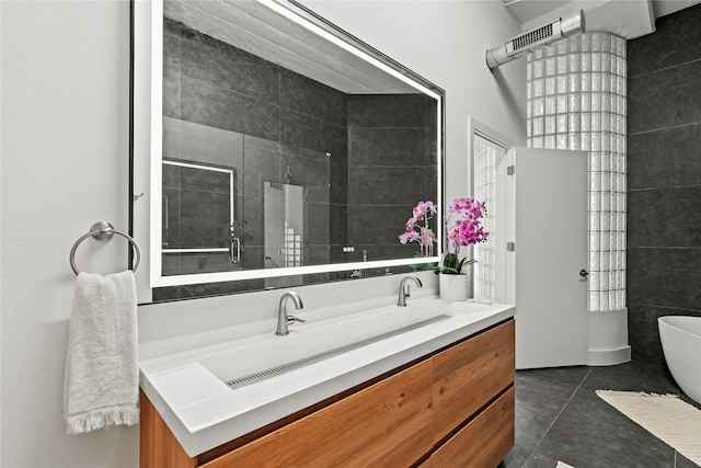 bathroom with vanity, tile patterned flooring, tile walls, and a shower