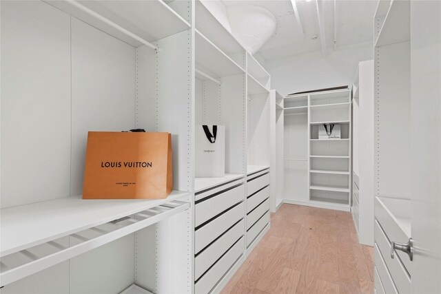 walk in closet with light hardwood / wood-style floors