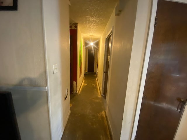 hall featuring a textured ceiling