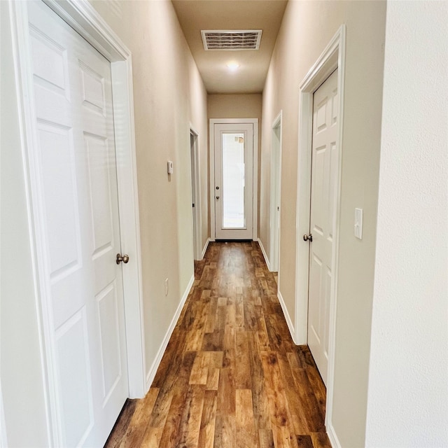 hallway with dark hardwood / wood-style flooring