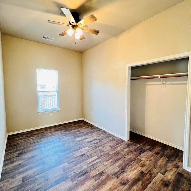 unfurnished bedroom featuring dark hardwood / wood-style flooring, a closet, and ceiling fan