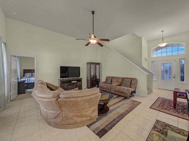 tiled living room featuring ceiling fan and high vaulted ceiling