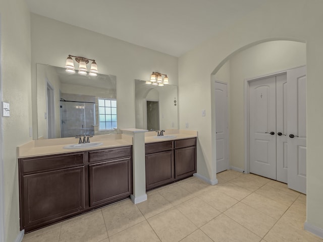 bathroom featuring vanity, a shower with shower door, and tile patterned flooring