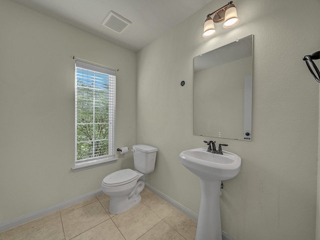 bathroom with sink, toilet, and tile patterned flooring