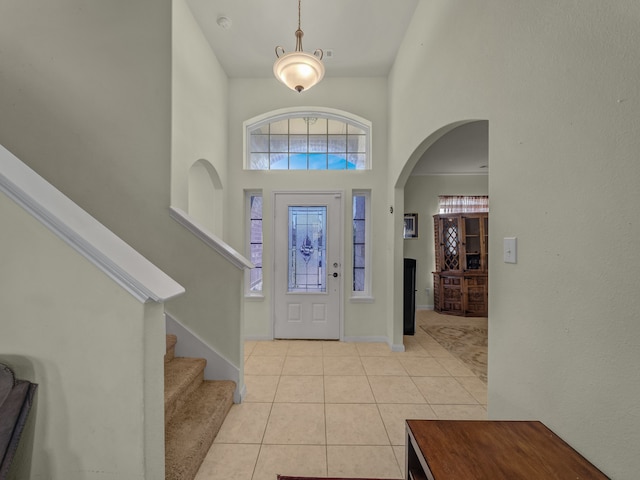 tiled foyer entrance with a towering ceiling