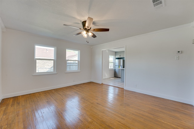 unfurnished room featuring crown molding, a healthy amount of sunlight, light wood-type flooring, and ceiling fan