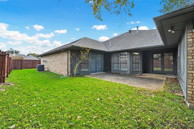 rear view of house featuring central AC and a yard