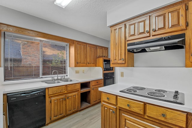 kitchen with light hardwood / wood-style flooring, a textured ceiling, black appliances, and sink