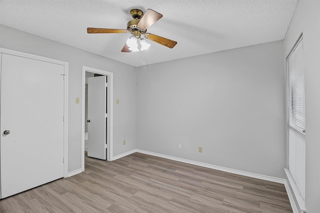 unfurnished bedroom featuring light hardwood / wood-style flooring, a textured ceiling, and ceiling fan