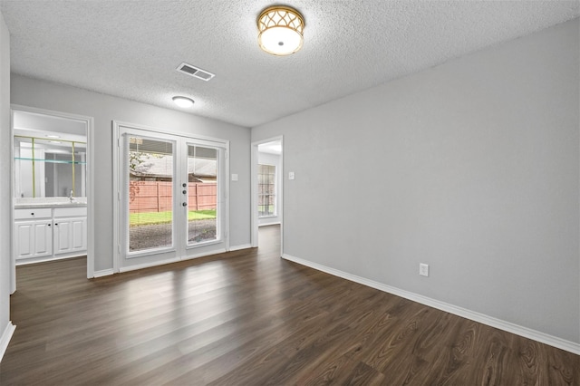 empty room with sink, a textured ceiling, and dark hardwood / wood-style flooring