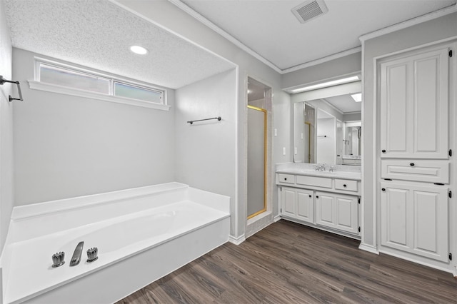 bathroom featuring hardwood / wood-style floors, separate shower and tub, a textured ceiling, vanity, and crown molding