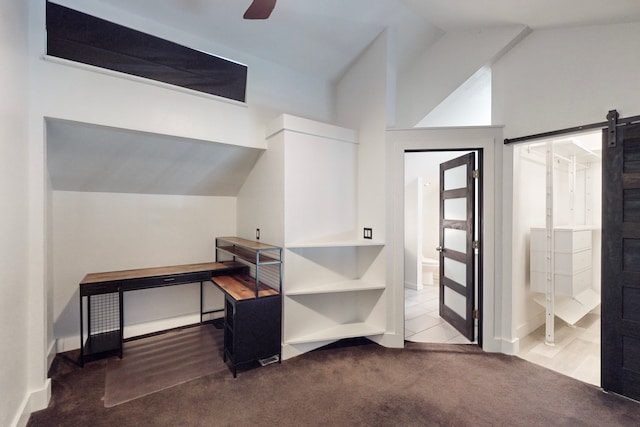 interior space with lofted ceiling, a barn door, and ceiling fan