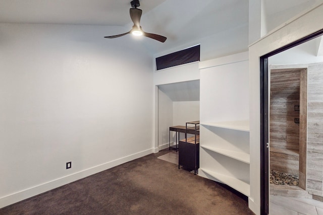 unfurnished bedroom featuring ceiling fan, dark colored carpet, and vaulted ceiling