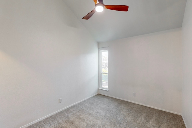 carpeted spare room with ceiling fan and vaulted ceiling