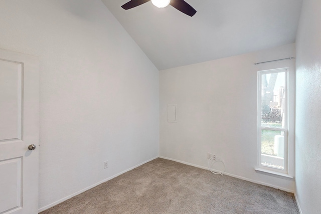 empty room featuring light carpet, ceiling fan, and vaulted ceiling