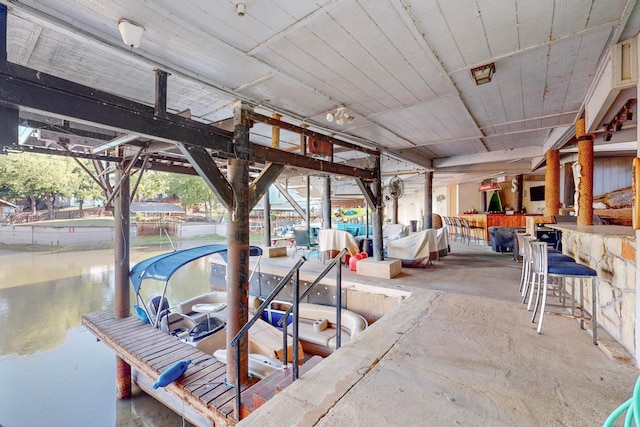 exterior space with exterior bar, a water view, and a boat dock