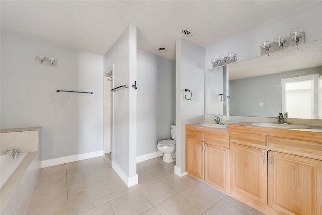 bathroom featuring vanity, toilet, tiled bath, and a textured ceiling