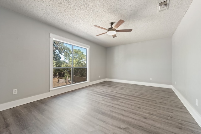 unfurnished room with a textured ceiling, ceiling fan, and dark hardwood / wood-style flooring