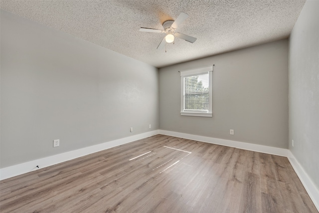 spare room featuring a textured ceiling, light wood-type flooring, and ceiling fan