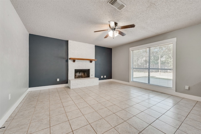 unfurnished living room with a textured ceiling, ceiling fan, and a brick fireplace