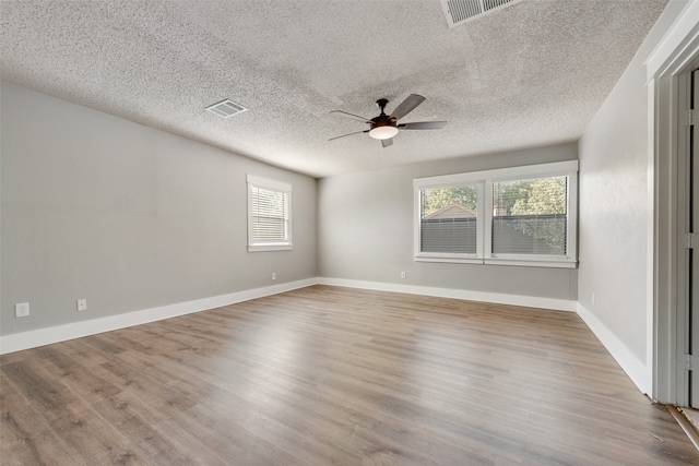 empty room featuring a textured ceiling, wood-type flooring, and ceiling fan