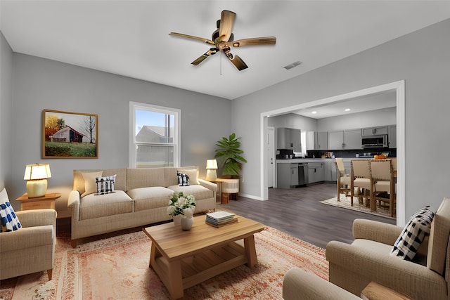 living room with wood-type flooring and ceiling fan