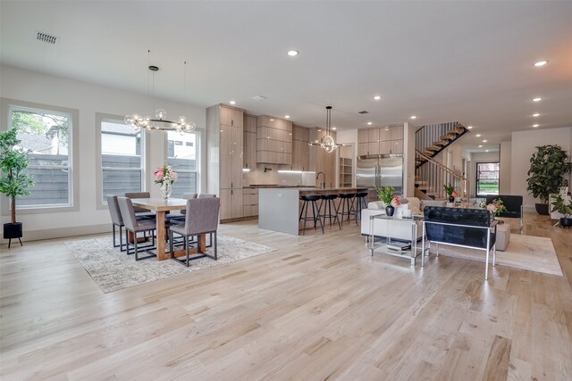 dining room with light hardwood / wood-style flooring, a notable chandelier, and a wealth of natural light