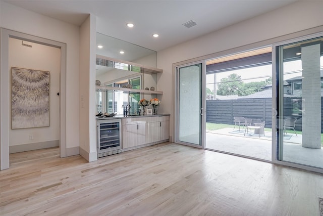 3732 Valley Ridge Rd, Dallas, TX 75220 - indoor wet bar featuring beverage cooler, healthy amount of natural light, light wood-style flooring, recessed lighting, and baseboards