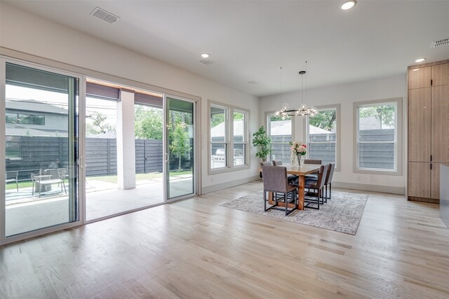 dining space with a chandelier and light hardwood / wood-style flooring