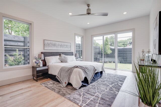 bedroom featuring multiple windows, access to exterior, light wood-type flooring, and ceiling fan