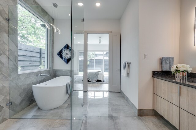 bathroom with tile walls, vanity, and separate shower and tub