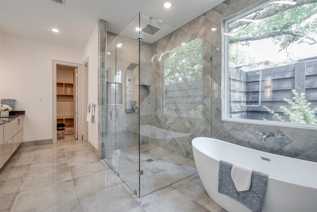 bathroom with vanity, shower with separate bathtub, and a healthy amount of sunlight