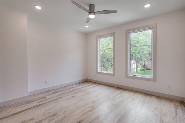 empty room with ceiling fan and light hardwood / wood-style flooring