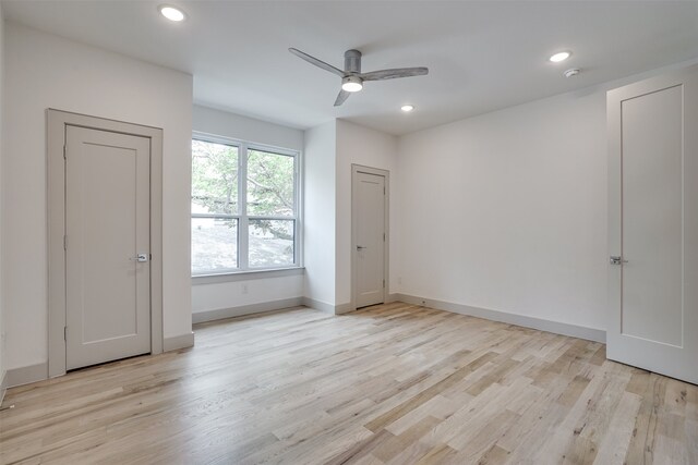 empty room with ceiling fan and light hardwood / wood-style flooring