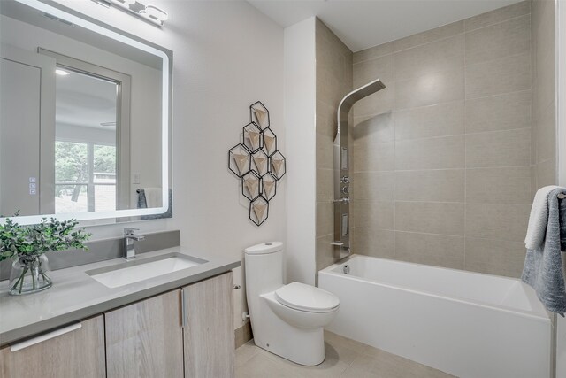 full bathroom featuring vanity, tiled shower / bath, toilet, and tile patterned flooring