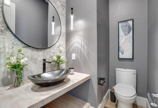 3732 Valley Ridge Rd, Dallas, TX 75220 - half bathroom with a sink, toilet, wood finished floors, baseboards, and tasteful backsplash